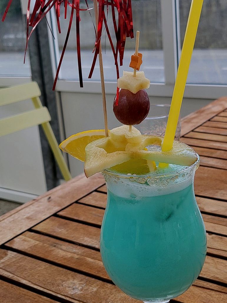 Cocktail bleu glacé décoré, servi en terrasse