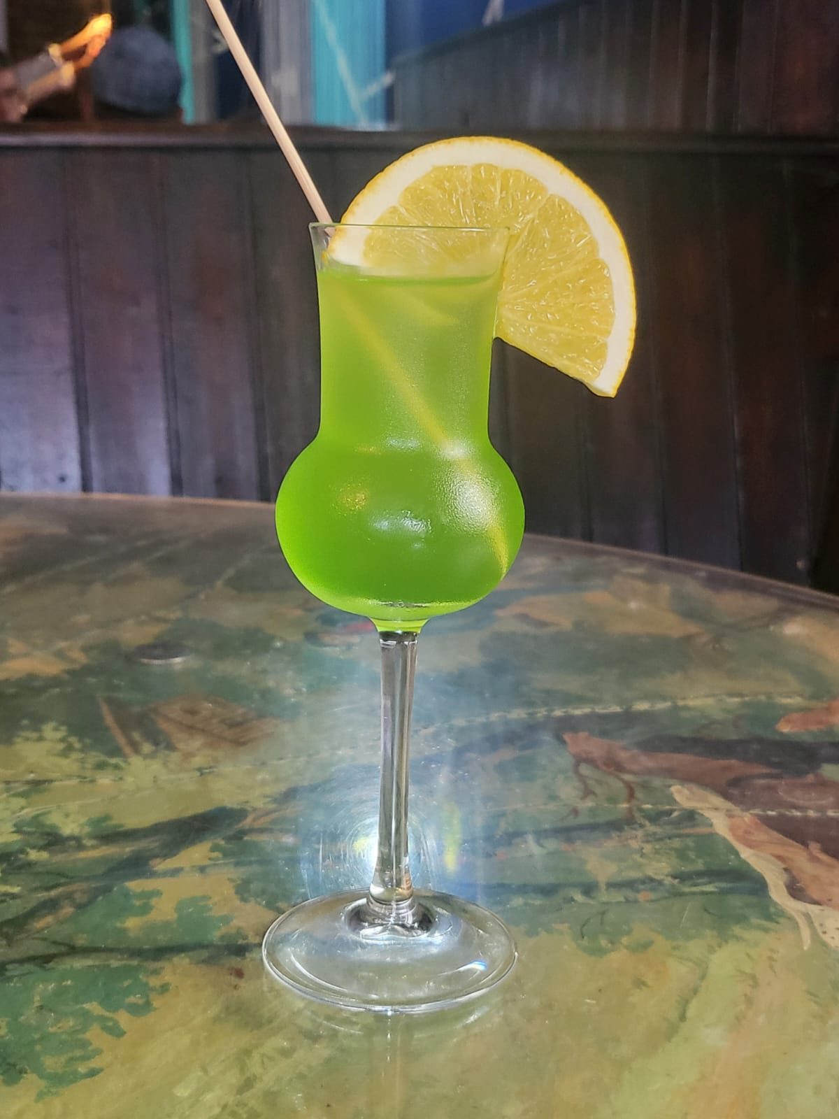 Cocktail vert dans son verre tulipe avec rondelle de citron