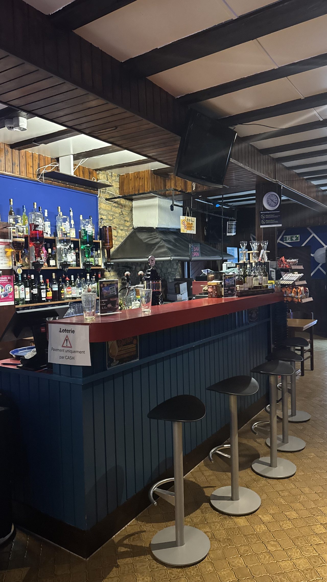 Le comptoir rouge du Bar Le Forgeron, en pierres et bois