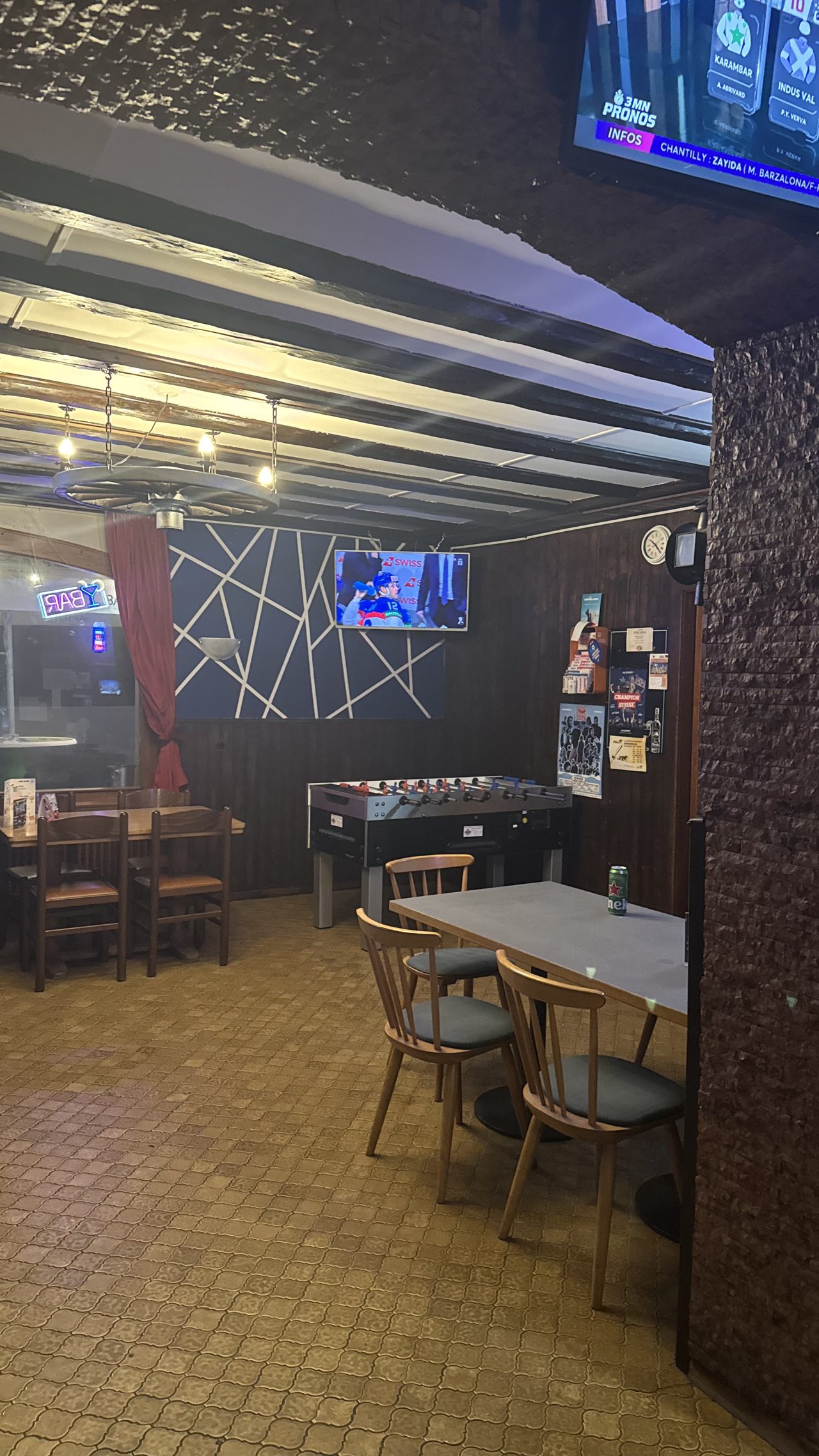 Baby-foot et tables dans la salle arrière du bar